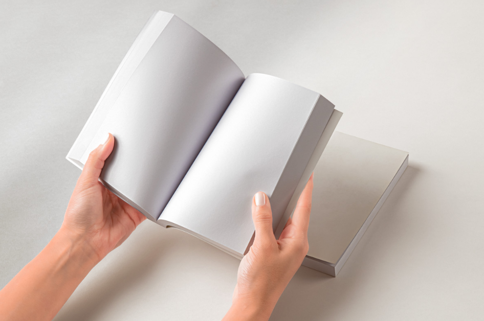 Hands Holding Open Paperback Book PSD Mockup