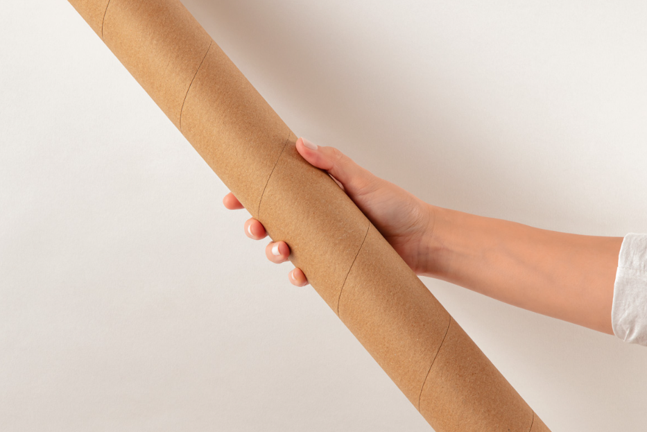 Hand Holding Kraft Tube mockup Packaging PSD