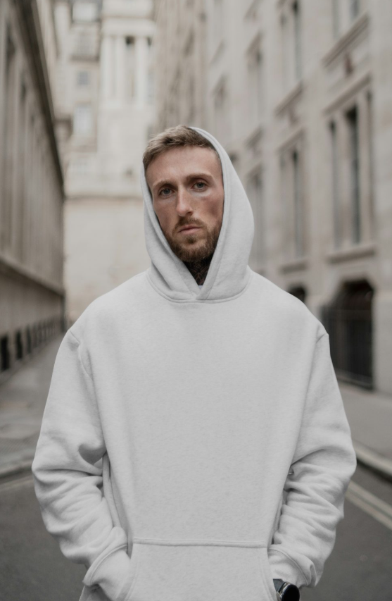 Men Wearing Hoodie Against The city Mockup